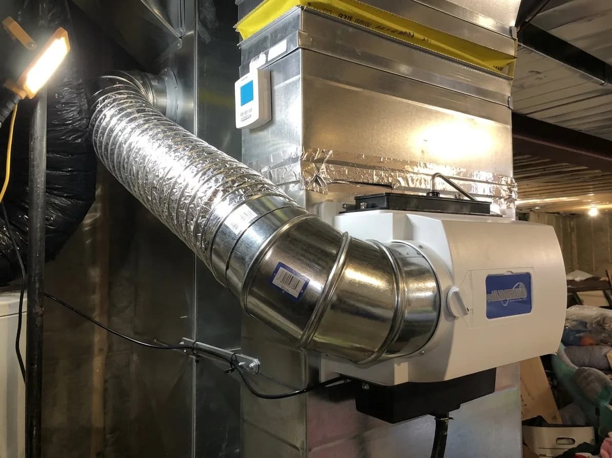 Whole-home air filtration unit integrated with residential ductwork.