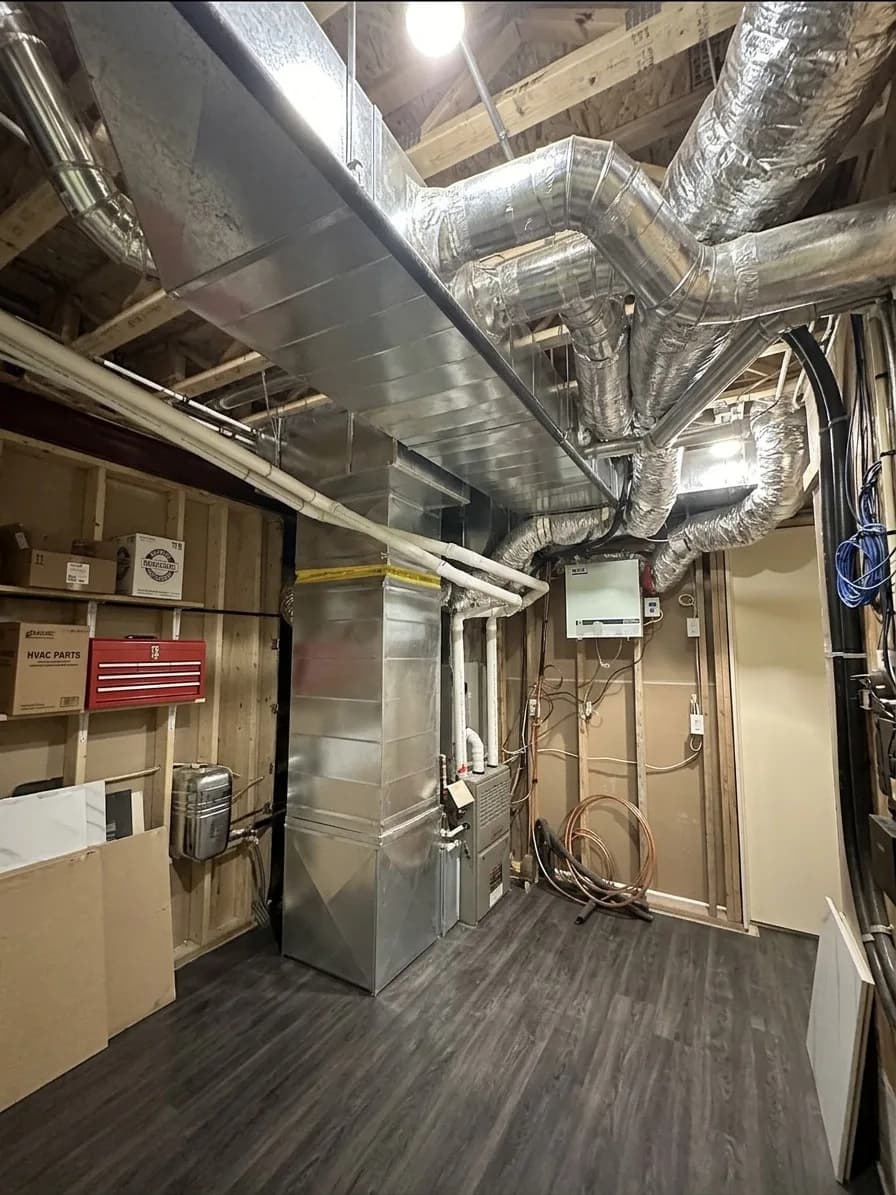 Furnace installed in a finished basement with clean ductwork.